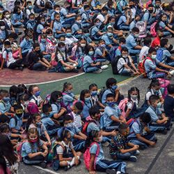 Un profesor da instrucciones a los alumnos durante su primer día de clase en el regreso a las escuelas tras el receso invernal en medio de la nueva pandemia de coronavirus, en Medellín, Colombia. | Foto:Joaquín Sarmiento / AFP