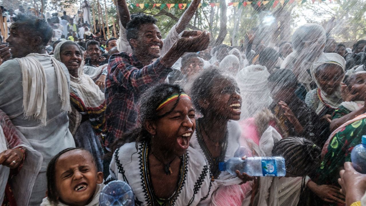 Los fieles ortodoxos etíopes son rociados con agua en el recinto de Fasilides Bath durante la celebración de Timkat, la Epifanía etíope, en la ciudad de Gondar, Etiopía. | Foto:EDUARDO SOTERAS / AFP