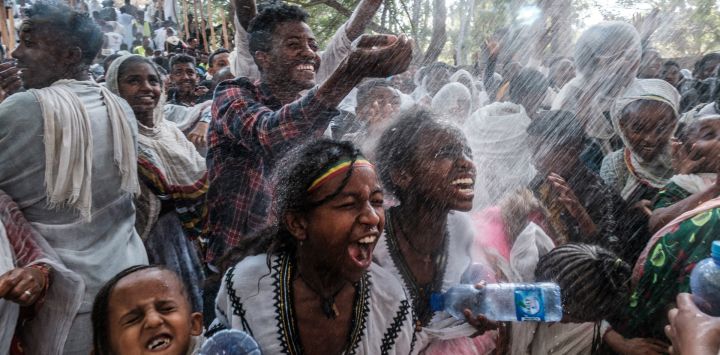 Los fieles ortodoxos etíopes son rociados con agua en el recinto de Fasilides Bath durante la celebración de Timkat, la Epifanía etíope, en la ciudad de Gondar, Etiopía.
