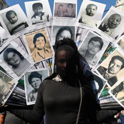 Un activista sostiene fotos de víctimas de la guerra civil durante una marcha para conmemorar el 30 aniversario de los acuerdos de paz que pusieron fin al conflicto armado (1980-1992) y para protestar contra el gobierno del presidente Nayib Bukele, en San Salvador. | Foto:MARVIN RECINOS / AFP