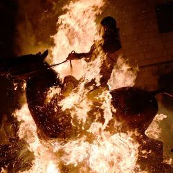 Un jinete atraviesa una hoguera en el pueblo de San Bartolomé de Pinares, en la provincia de Ávila, en el centro de España, durante la tradicional fiesta religiosa de "Las Luminarias" en honor a San Antonio, patrón de los animales. | Foto:PIERRE-PHILIPPE MARCOU / AFP