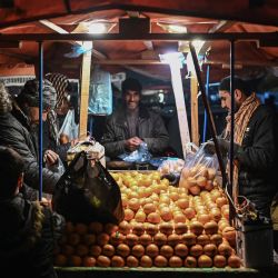 Un vendedor vende mandarinas en un puesto de carretera en Kabul, Afganistan. | Foto:MOHD RASFAN / AFP