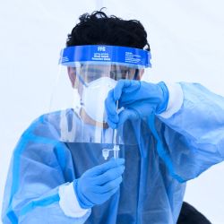 Un trabajador sanitario coloca un hisopo de prueba en la solución para una prueba rápida de antígeno Covid-19 en un centro de pruebas de Reliant Health Services en Hawthorne, California. | Foto:PATRICK T. FALLON / AFP