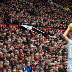 La gente mira desde la tribuna mientras un jugador realiza un saque de banda durante el partido de fútbol de la Premier League inglesa entre el Manchester United y el West Ham United en Old Trafford en Manchester, noroeste de Inglaterra. | Foto:OLI SCARFF / AFP
