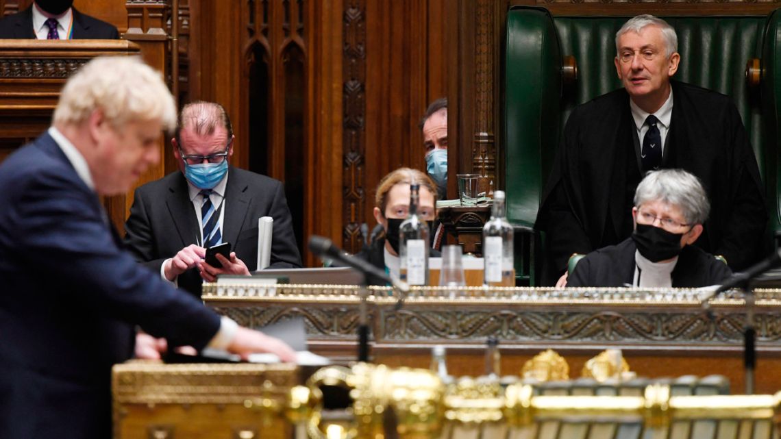 A handout photograph released by the UK Parliament shows Speaker of the House Lindsay Hoyle (R) listening as Britain's Prime Minister Boris Johnson speaks to MPs to update them on the situation in Ukraine, in the House of Commons in London on January 25, 2022.