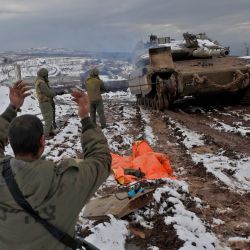 Soldados israelíes junto a un carro de combate Merkava IV estacionado en un puesto militar cerca de la frontera con Siria en los Altos del Golán anexionados por Israel. - Siria y Rusia iniciaron patrullas conjuntas de las fuerzas aéreas cerca de la frontera israelí. | Foto:JALAA MAREY / AFP