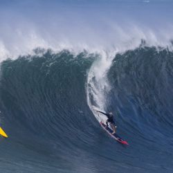 El bicampeón de la Liga Mundial de Surf, John John Florence, se sube a una ola en la bahía de Waimea, Hawái. - La bahía de Waimea, en la costa norte de Oahu, es famosa por sus olas de 9 metros. | Foto:Brian Bielmann / AFP