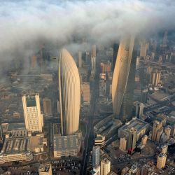 Esta vista aérea muestra la torre al-Hamra, la sede del Banco Nacional de Kuwait y la torre al-Rayah, envueltas en una espesa niebla. | Foto:YASSER AL-ZAYYAT / AFP