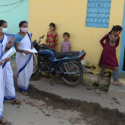 Trabajadores sanitarios caminan por una calle mientras realizan una encuesta puerta a puerta para identificar a las personas con síntomas del coronavirus Covid-19 en un barrio marginal de Hyderabad, India. | Foto:NOAH SEELAM / AFP