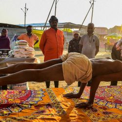 Un asceta realiza yoga en su tienda improvisada cerca de las orillas de Sangam, durante el festival Magh Mela en Allahabad, India. | Foto:SANJAY KANOJIA / AFP