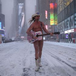 The Naked Cowboy actúa durante una tormenta de nieve en Times Square, Nueva York. - Una poderosa tormenta invernal con fuertes nevadas y vientos azotó la costa este de Estados Unidos, obligando a la cancelación de miles de vuelos al tiempo que se emitieron alertas de mal tiempo en una región de unos 70 millones de personas. | Foto:ED JONES / AFP