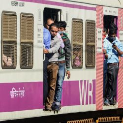 Los pasajeros viajan en un tren de cercanías abarrotado en Mumbai, India. | Foto:SUJIT JAISWAL / AFP