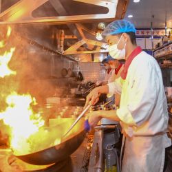 Un chef cocina en un restaurante, en el distrito de Nankai, en Tianjin, en el norte de China. En áreas clasificadas como de bajo riesgo para la COVID-19 en Tianjin, algunos restaurantes han introducido el servicio para llevar para las fiestas de vacaciones. El servicio no solo satisface la demanda de los clientes sino también puede ayudar a prevenir la propagación de la COVID-19. | Foto:Xinhua/Sun Fanyue