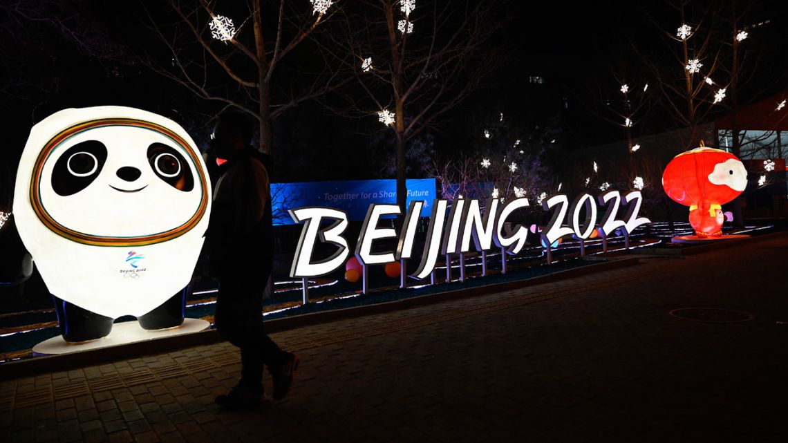 A man walks past installations of Bing Dwen Dwen and Shuey Rhon Rhon, mascots of the Beijing 2022 Winter Olympics Games, along a street in Beijing on January 28, 2022.