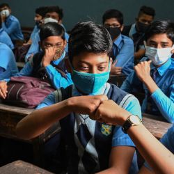 Alumnos reaccionan mientras asisten a una clase después de que las escuelas reanudaran las clases físicas que fueron cerradas anteriormente para frenar la propagación del coronavirus Covid-19 en Calcuta, India. | Foto:DIBYANGSHU SARKAR / AFP