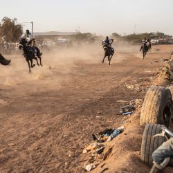 Un niño se sienta en su bicicleta mientras observa una carrera de caballos en Uagadugú, Burkina Faso. | Foto:JOHN WESSELS / AFP