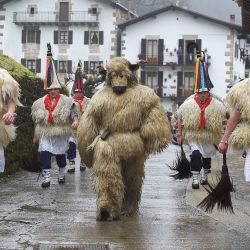 Un participante disfrazado de 'oso' desfila con los campaneros, conocidos como "Joaldunak" en euskera, que marchan con grandes cencerros colgados a la espalda durante el tradicional carnaval de Ituren, en la localidad navarra de Ituren, al norte de España. | Foto:ANDER GILLENEA / AFP