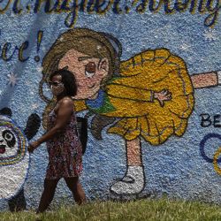 Una mujer camina frente a un mural sobre los Juegos Olímpicos de Invierno de Beijing 2022, en Brasilia, Brasil. | Foto:Xinhua/Lucio Tavora