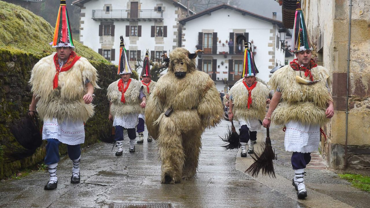 Un participante disfrazado de 'oso' desfila con los campaneros, conocidos como "Joaldunak" en euskera, que marchan con grandes cencerros colgados a la espalda durante el tradicional carnaval de Ituren, en la localidad navarra de Ituren, al norte de España. | Foto:ANDER GILLENEA / AFP