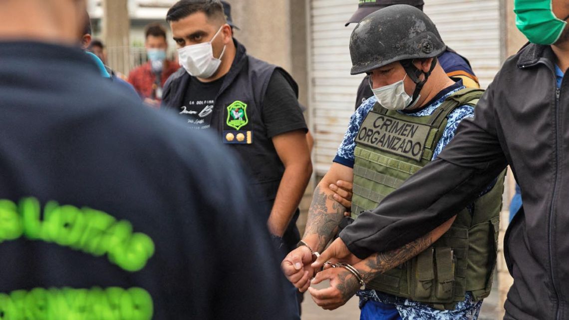Police officers escort Joaquín Aquino, also known as 'El Paisa', accused of distributing adulterated cocaine in José C. Paz, Buenos Aires Province on February 3, 2022.