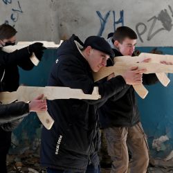 Civiles se entrenan para sostener réplicas de madera de rifles Kalashnikov, mientras participan en una sesión de entrenamiento en una fábrica abandonada en la capital ucraniana de Kiev. - En medio de los temores de una posible invasión por parte de las tropas rusas concentradas en la frontera ucraniana, en el marco del entrenamiento se imparten clases de táctica, paramédico, entrenamiento en la pista de obstáculos. El entrenamiento está dirigido por instructores con experiencia en combate, miembros del movimiento "Resistencia Total". | Foto:SERGEI SUPINSKY / AFP
