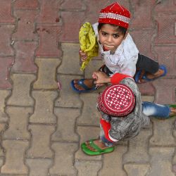 Un niño lleva un libro religioso mientras camina por un sendero en la India. | Foto:Sajjad Hussain / AFP