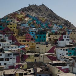 Una vista aérea muestra el recientemente coloreado poblado de chabolas de Leticia en el cerro de San Cristóbal, situado en la periferia del centro de Lima, que recibió un colorido lavado de cara por parte de sus propios residentes dirigidos por artistas muralistas. | Foto:CRIS BOURONCLE / AFP