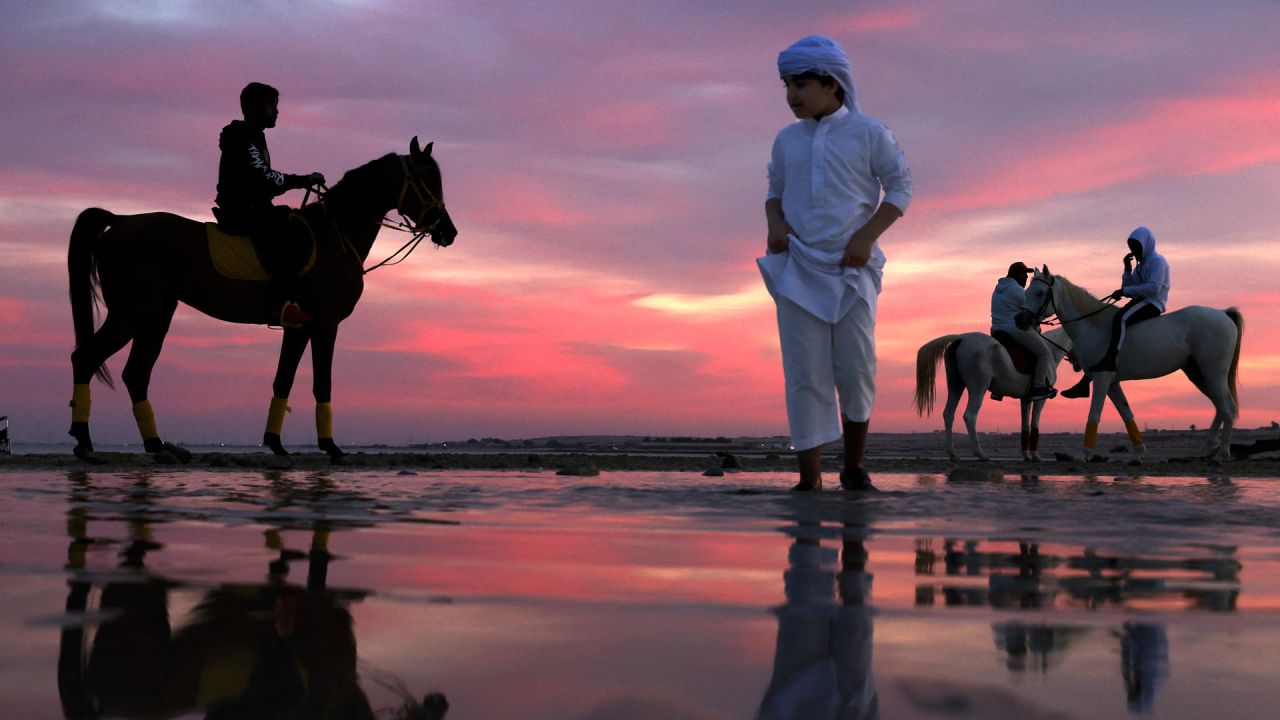 Emiratíes montan a caballo durante la puesta de sol en Abu Dhabi. | Foto:KARIM SAHIB / AFP