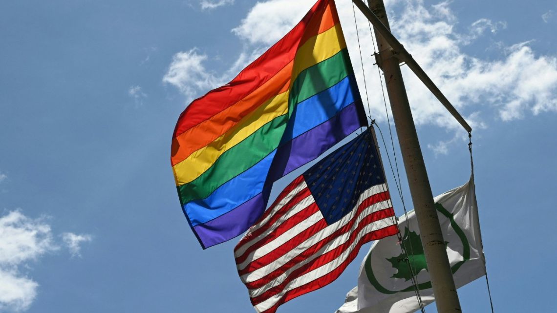 a Rainbow flag and a US Flag fly at the Stonewall National Monument, the first LGBTQ national monument, dedicated to the birthplace of modern lesbian, gay, bisexual, transgender, and queer civil rights movement in New York City.