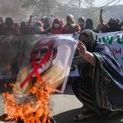 Un activista del "Awami Rickshaw Union" prende una pancarta con el retrato del primer ministro de la India, Narendra Modi, durante una manifestación en Lahore, para protestar después de que se dijera a las estudiantes de los institutos gestionados por el gobierno en el estado indio de Karnataka que no llevaran el pañuelo islámico "hijabs" en las instalaciones del instituto. | Foto:ARIF ALI / AFP