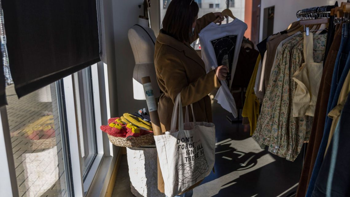 A shopper browses for clothes at a shop.