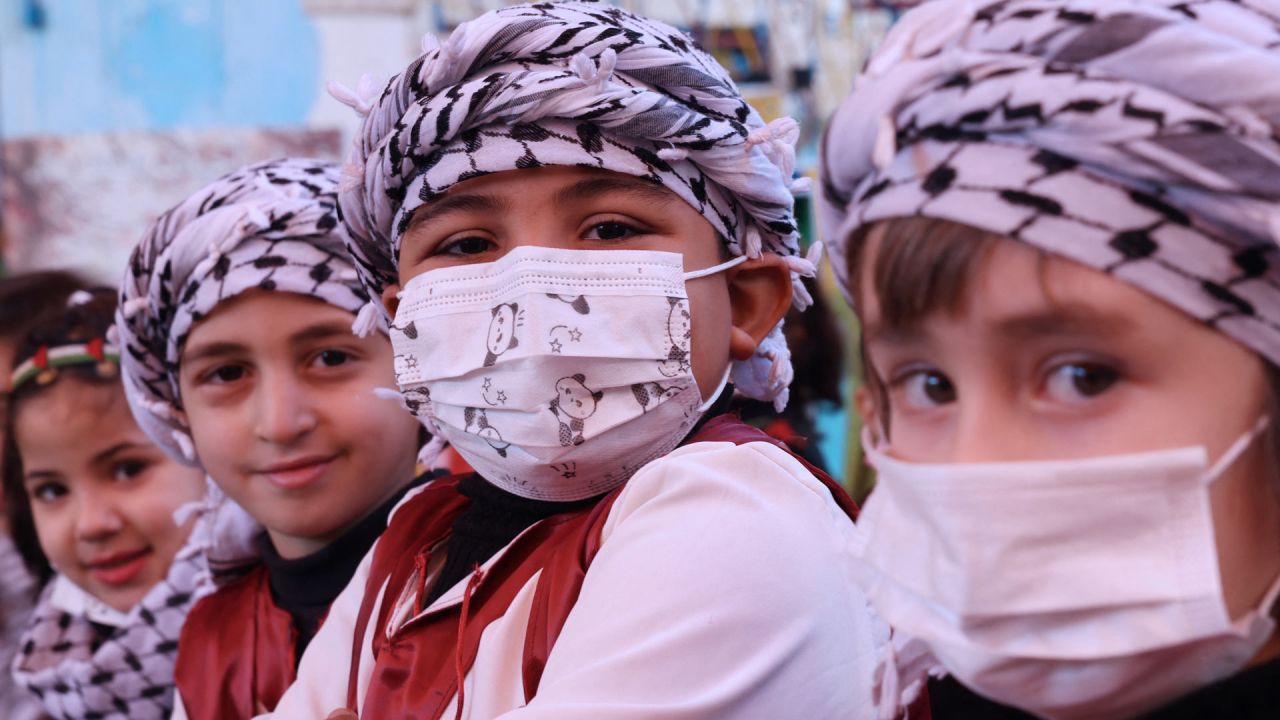Niños palestinos de un jardín de infantes esperan en fila con sus máscaras protectoras puestas durante un día de terapia de juego en su escuela en la ciudad de Gaza. | Foto:MOHAMMED ABED / AFP