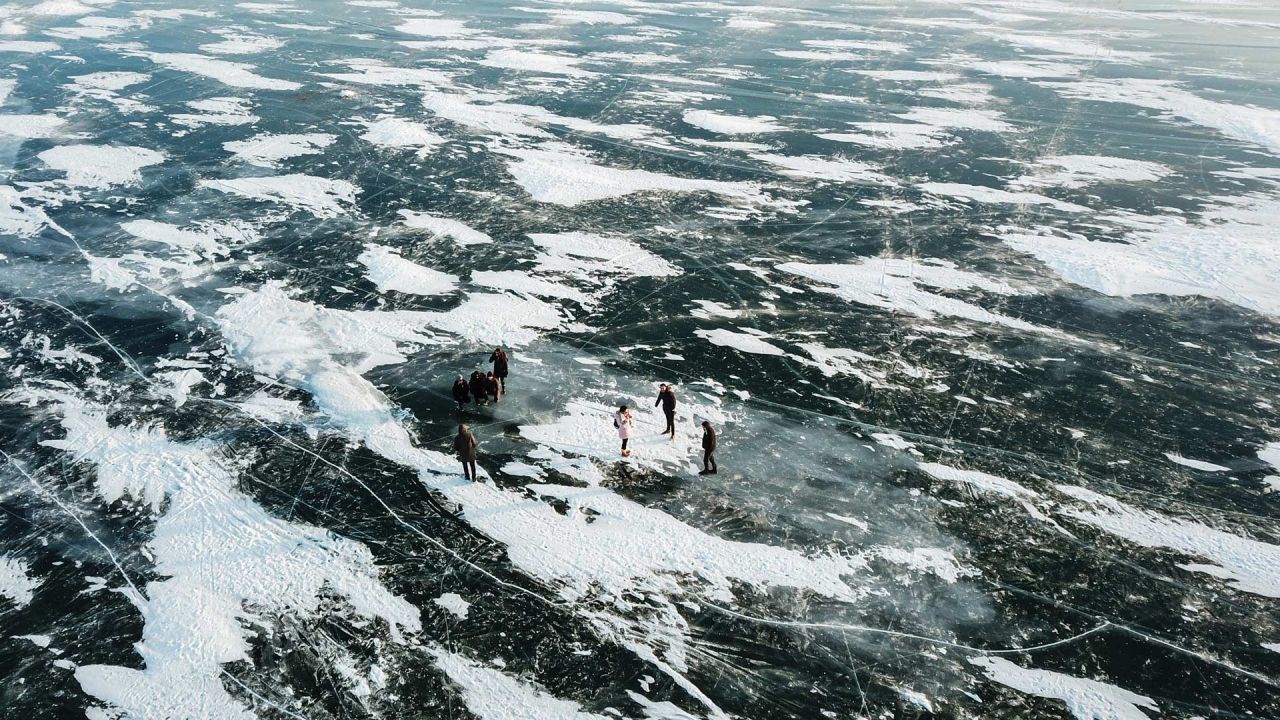 En esta vista aérea turistas y guías caminan sobre el hielo del lago Cildir al atardecer, en el distrito de Cildir en Kars. - Entre diciembre y marzo, cuando el hielo es lo suficientemente grueso, Orhan Goller, de 19 años, que vive junto al lago Cildir, introduce a los turistas en su región. El lago es uno de los más grandes de Anatolia, en la frontera con Georgia. | Foto:OZAN KOSE / AFP
