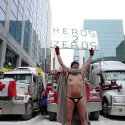 Un manifestante sostiene un cartel mientras los manifestantes siguen protestando contra los mandatos de Covid-19 en Ottawa, Canadá. | Foto:Dave Chan / AFP