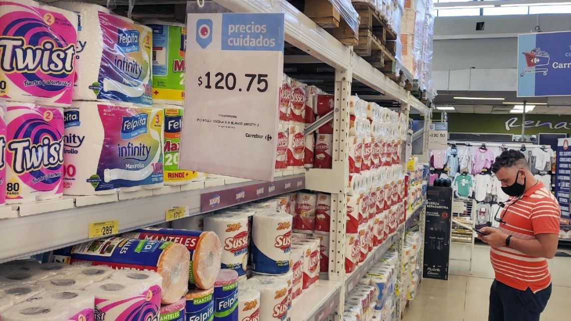 A shopper checks prices in a supermarket in Buenos Aires.
