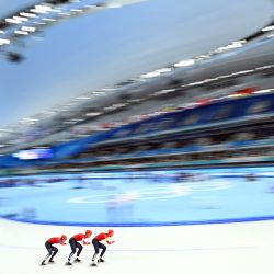 Los noruegos Peder Kongshaug, Hallgeir Engebraaten y Sverre Lunde Pedersen compiten en la final A de persecución por equipos de patinaje de velocidad masculino durante los Juegos Olímpicos de Invierno de Pekín 2022. | Foto:SEBASTIEN BOZON / AFP