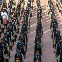 Alumnas de una escuela secundaria y preuniversitaria gubernamental para mujeres se reúnen para la asamblea de oración dentro de las instalaciones del instituto educativo en Bangalore, después de que las escuelas reabrieran en el sur de la India bajo fuertes medidas de seguridad después de que las autoridades prohibieran las reuniones públicas tras las protestas por el uso del hijab por parte de las niñas musulmanas en las aulas. | Foto:Manjunath Kiran / AFP