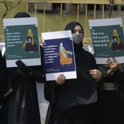 Miembros de la Asociación de Mujeres Musulmanas sostienen pancartas mientras permanecen junto a una carretera durante una protesta silenciosa después de que algunos institutos educativos de Karnataka denegaran la entrada a estudiantes que llevan hijabs, en India | Foto:NOAH SEELAM / AFP