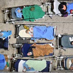 La gente duerme en las camas del hospital con las temperaturas cayendo por la noche fuera del Centro Médico de Caritas en Hong Kong, mientras los hospitales se ven desbordados con la ciudad enfrentando su peor ola de coronavirus Covid-19 hasta la fecha. | Foto:PETER PARKS / AFP
