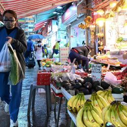 La gente pasa por delante de una tienda que vende productos en un mercado de Hong Kong, mientras la ciudad se enfrenta a su peor brote de Covid-19 desde el inicio de la pandemia. | Foto:PETER PARKS / AFP