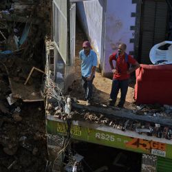 Los residentes observan una escena de destrucción durante el tecer día de operaciones en el lugar de un deslizamiento de tierra en Petrópolis, Brasil. | Foto:CARL DE SOUZA / AFP