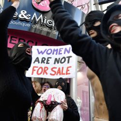 Miembros del colectivo feminista francés "Les Amazones" participan en una acción frente al sex shop "Jacquie et Michel" para denunciar la condición de las mujeres en la industria del porno en París. | Foto:JULIEN DE ROSA / AFP