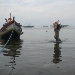 Un pescador carga una bolsa con conchas marinas descargadas de un barco de madera, en Yakarta, Indonesia. | Foto:Xinhua/Zulkarnain