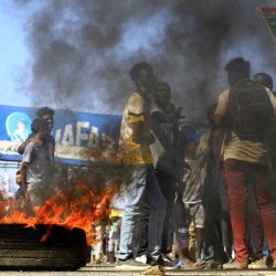 Manifestantes sudaneses queman neumáticos y sostienen imágenes de manifestantes asesinados en protestas anteriores, durante una marcha que pide un gobierno civil y denuncia la administración militar en la ciudad de Jartum Norte, cerca de la capital. | Foto:AFP