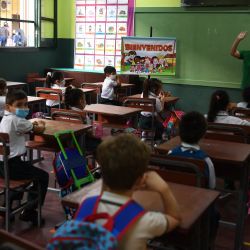 Niños asisten a una clase en una escuela pública en el primer día de clases presenciales después de dos años y medio de aprendizaje a distancia debido a la pandemia de COVID-19, en Asunción, Paraguay. | Foto:NORBERTO DUARTE / AFP