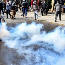 Un manifestante devuelve un bote de gas lacrimógeno a la policía durante una protesta contra el acuerdo de subvención propuesto por Estados Unidos en el marco de la Corporación del Desafío del Milenio (MCC), en Katmandú, Nepal. | Foto:PRAKASH MATHEMA / AFP