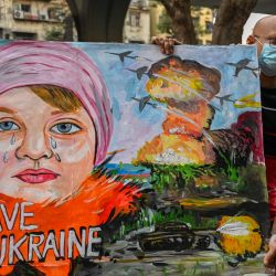 Un profesor de arte lleva una pintura para condenar la operación militar de Rusia en Ucrania, en Bombay, India. | Foto:PUNIT PARANJPE / AFP