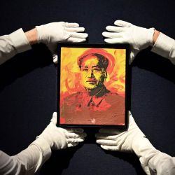 Asistentes de la galería sostienen una obra de arte titulada "Mao" del artista estadounidense Andy Warhol durante un photocall en la casa de subastas Christie's de Londres. - Se estima que la obra se venderá por 600.000-800.000 libras esterlinas (700.000-950.000 euros, 800.000-1,1 millones de dólares). | Foto:JUSTIN TALLIS / AFP