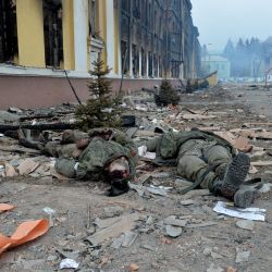 Los cuerpos de los soldados rusos yacen frente a una escuela destruida como resultado del combate no lejos del centro de la ciudad ucraniana de Kharkiv, situada a unos 50 km de la frontera ucraniano-rusa. | Foto:SERGEY BOBOK / AFP