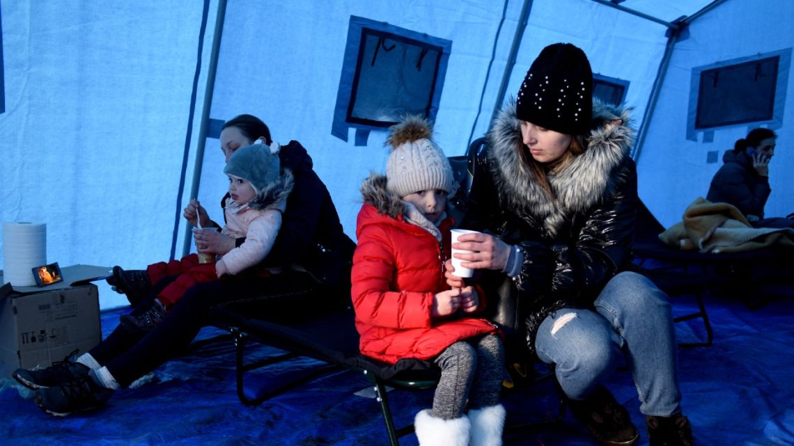 Women feed children inside a tent set near Lviv main railway station in Western Ukraine on February 28, 2022.